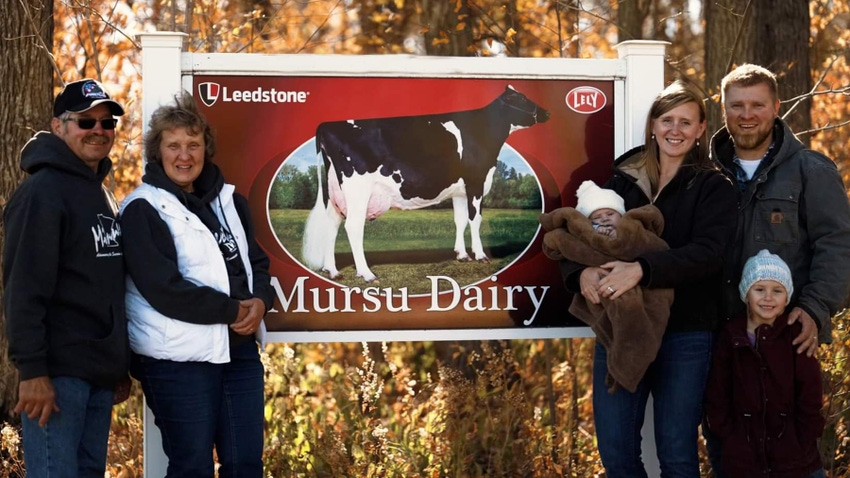 Six members of Mursu family next to Mursu Dairy sign