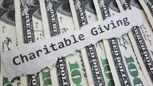 A newspaper clipping with the words "charitable giving" against a background of $100 bills