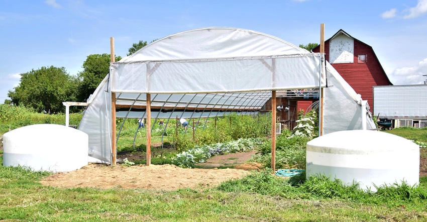 greenhouse behind a barn