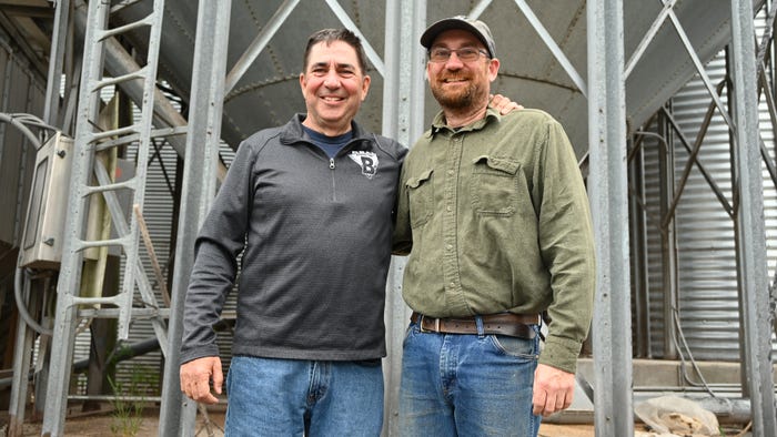 Bill and Matthew Beam standing in front of grain bins Bill and Matthew Beam standing in front of grain bins