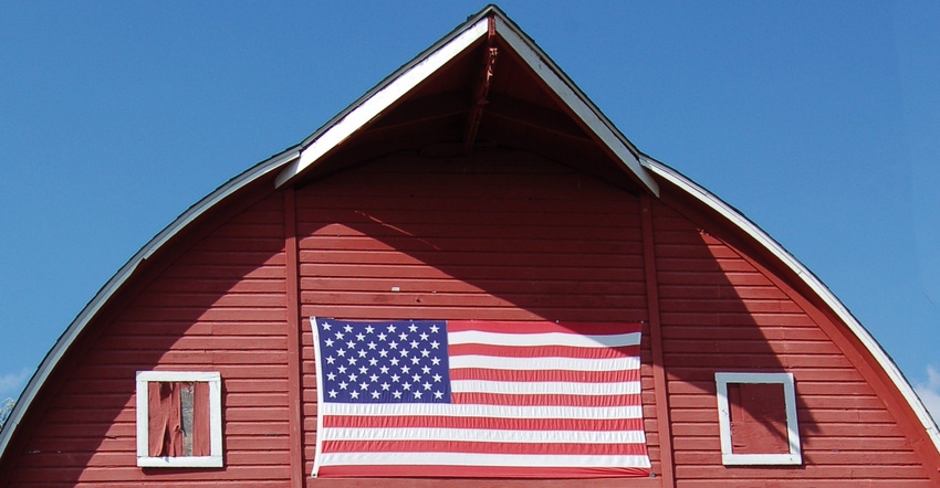 red barn with flag painted on the supper portion against blue sky