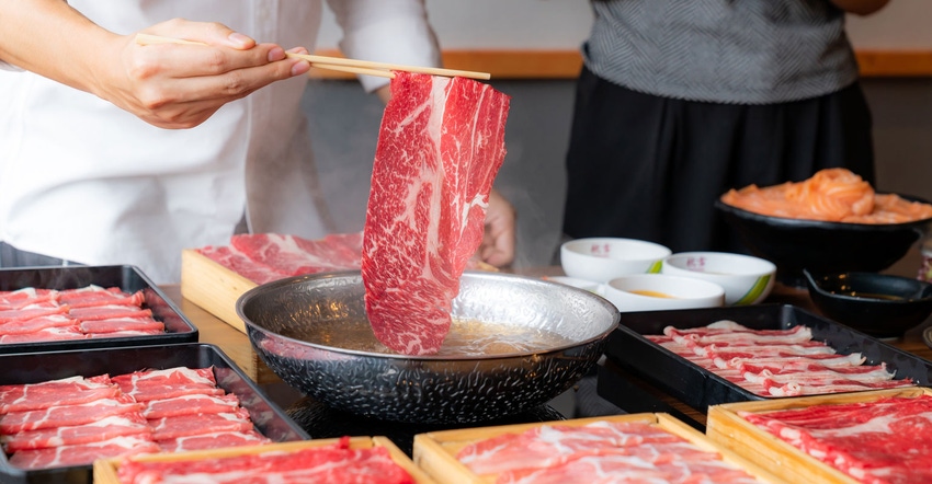 Close-up of a hotpot where meats are sliced thin and cooked at the table