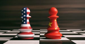 USA and China flags on chess pawns on a chessboard.