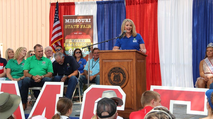 Chris Chinn standing behind a podium on a stage