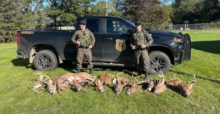 Conservation officers Tyler Cole and Matt Page with the heads of eight poached deer