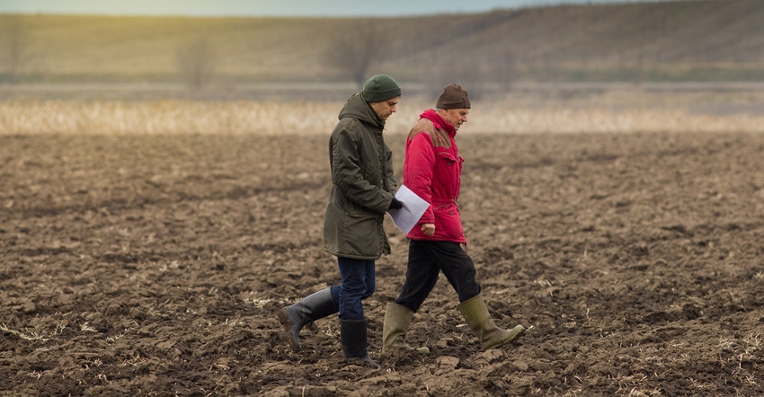 TWO FARMERS WALKING IN FIELD