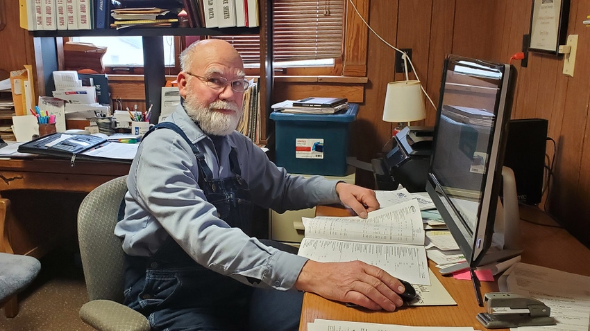 Farmer Terry Pope sitting at computer in farm office