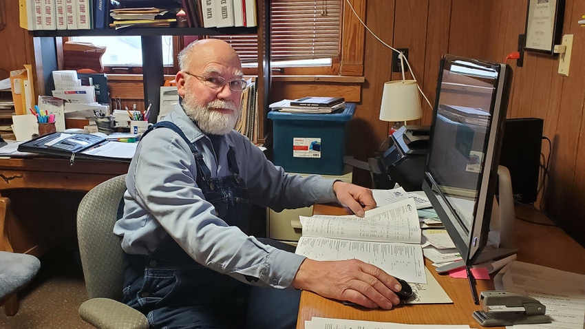 Farmer Terry Pope sitting at computer in farm office Farmer Terry Pope sitting at computer in farm office