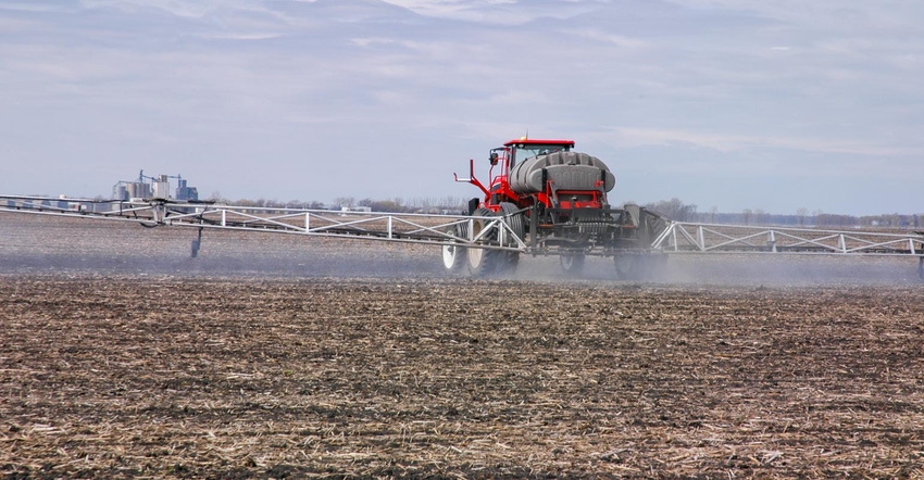 A tractor spraying herbicides on a field