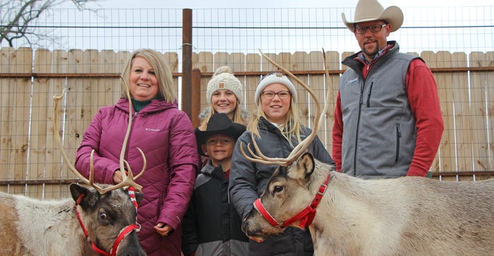 The Prescott family poses with two reindeer The Prescott family poses with two reindeer