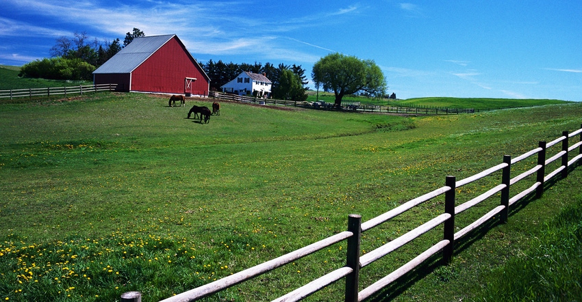 Farmland, red barn and horses in field