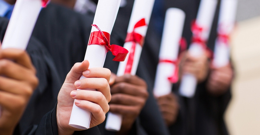 row of diplomas in the hands of graduates