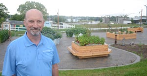 Gary Slater, Iowa State Fair manager with vegetable gardens in background at  Iowa State Fair 