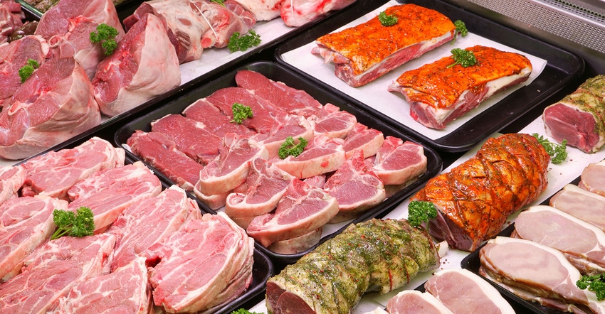 selection of raw meat trays in a butcher display cooler