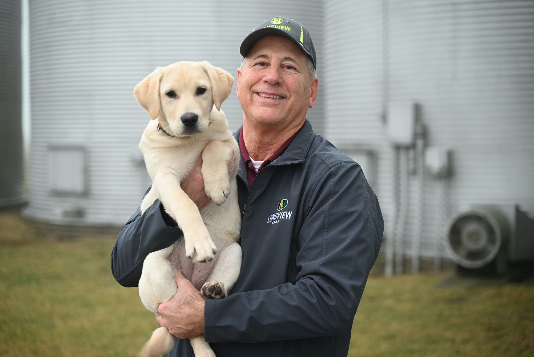 Chris Hausman holding a yellow labrador retriever puppy
