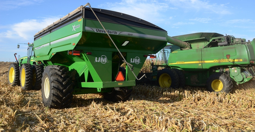 combine and grain cart in field harvesting corn