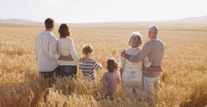 Family hugging in wheat field