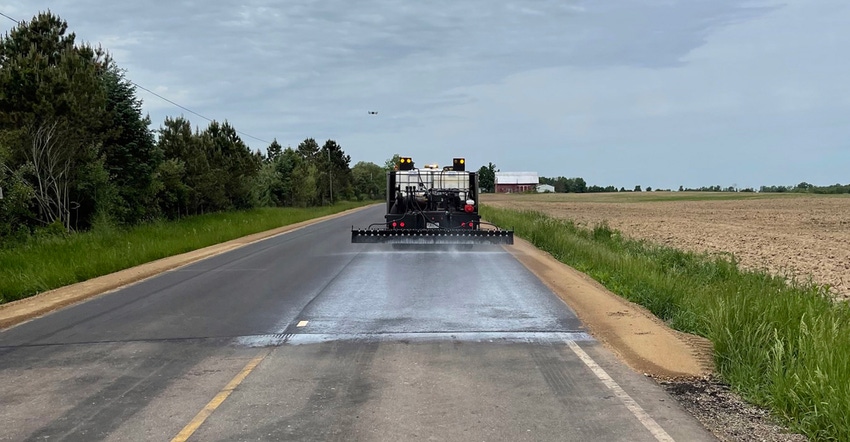 truck applying sealant to asphalt