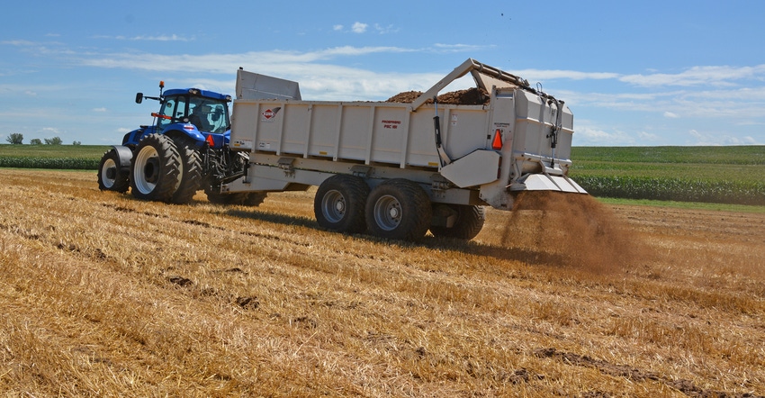 truck driving through field spreading manure truck driving through field spreading manure