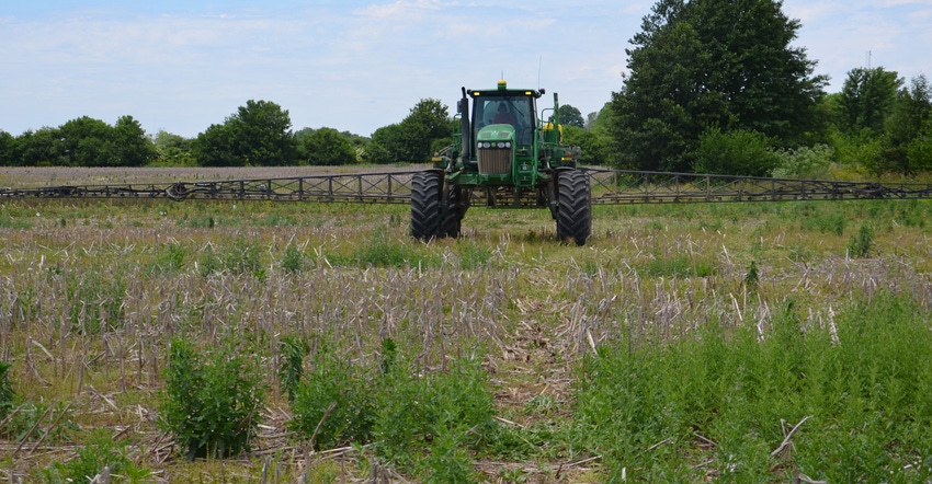tractor and sprayer in field of corn residue and weeds