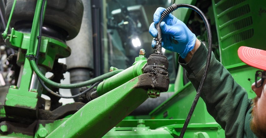 technician working on farm equipment