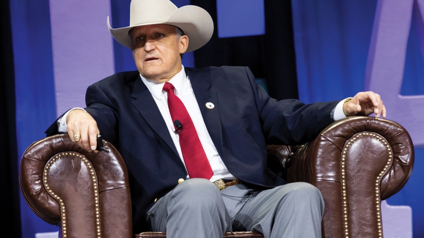 man wearing cowboy hat and suit seated in armchair man wearing cowboy hat and suit seated in armchair