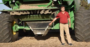 Prashant Jha shows off the chaff-gathering tool attached to a combine. The 