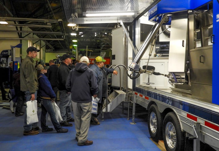 Farmers look at the latest in robotic milking technology at the New York Farm Show