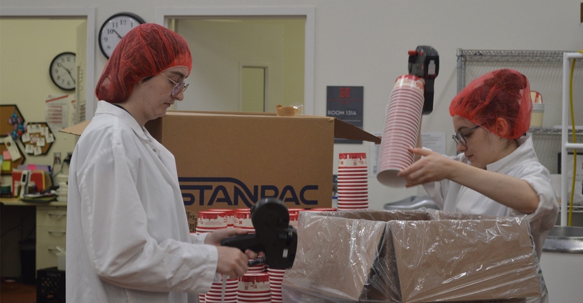 Two UNL students in FPC’s Dairy Plant are preparing cups for the day’s production of ice cream, 