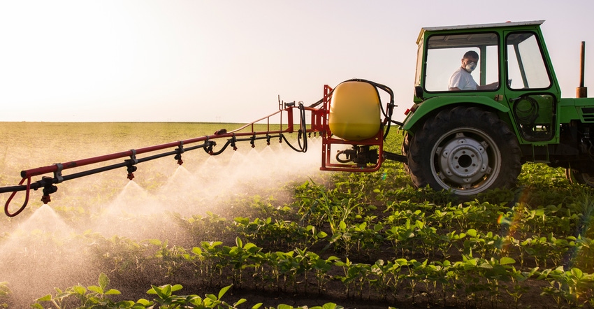 tractor spraying soybean plants