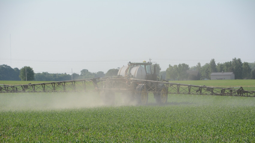equipment spraying cornfield with herbicide