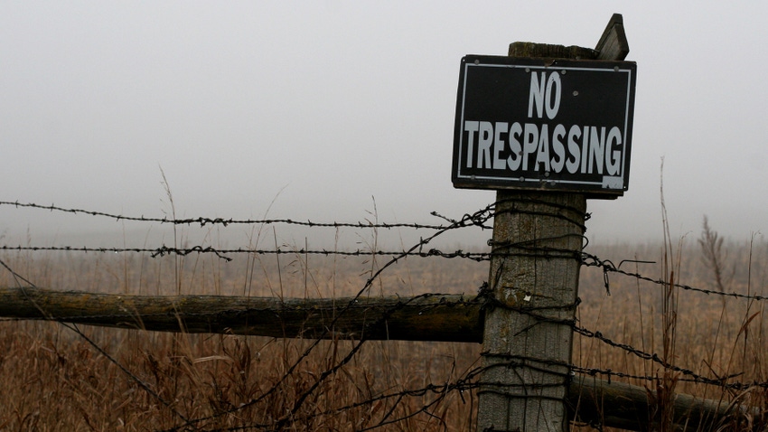 no trespassing sign on a fence post