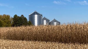 Crop field with grain bins in background