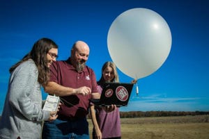 students and professor launch weather balloon