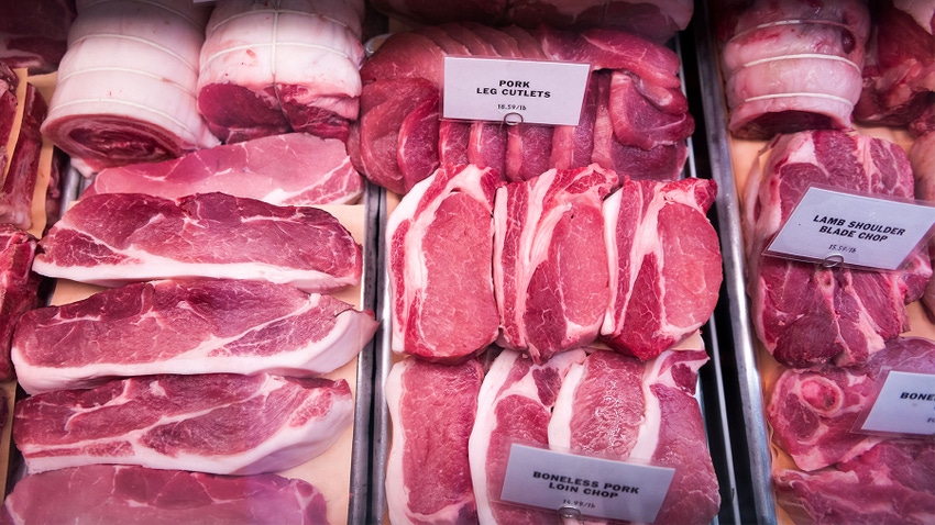 A close-up of a meat shelf at a butcher counter with various cuts of pork  