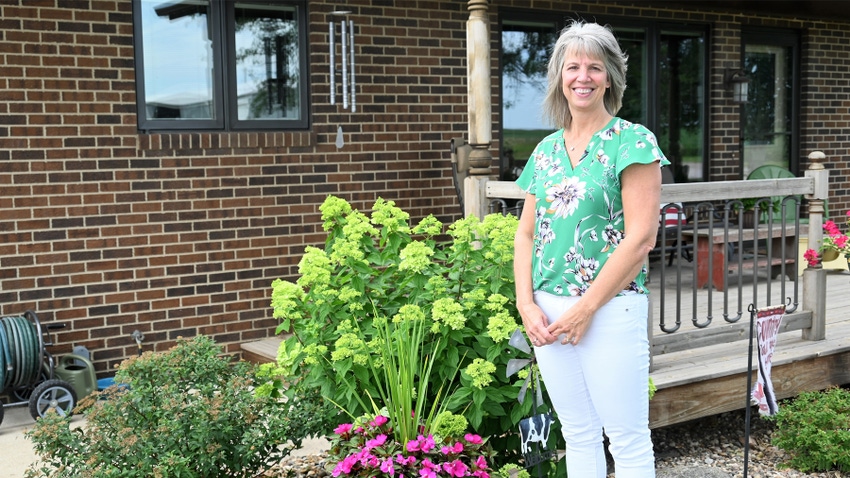 Cherie Westerkamp stanging outside house with garden plantings