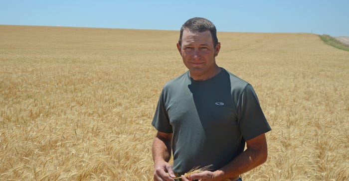 Brent Robertson standing in wheat field