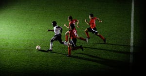 Soccer players chasing ball
