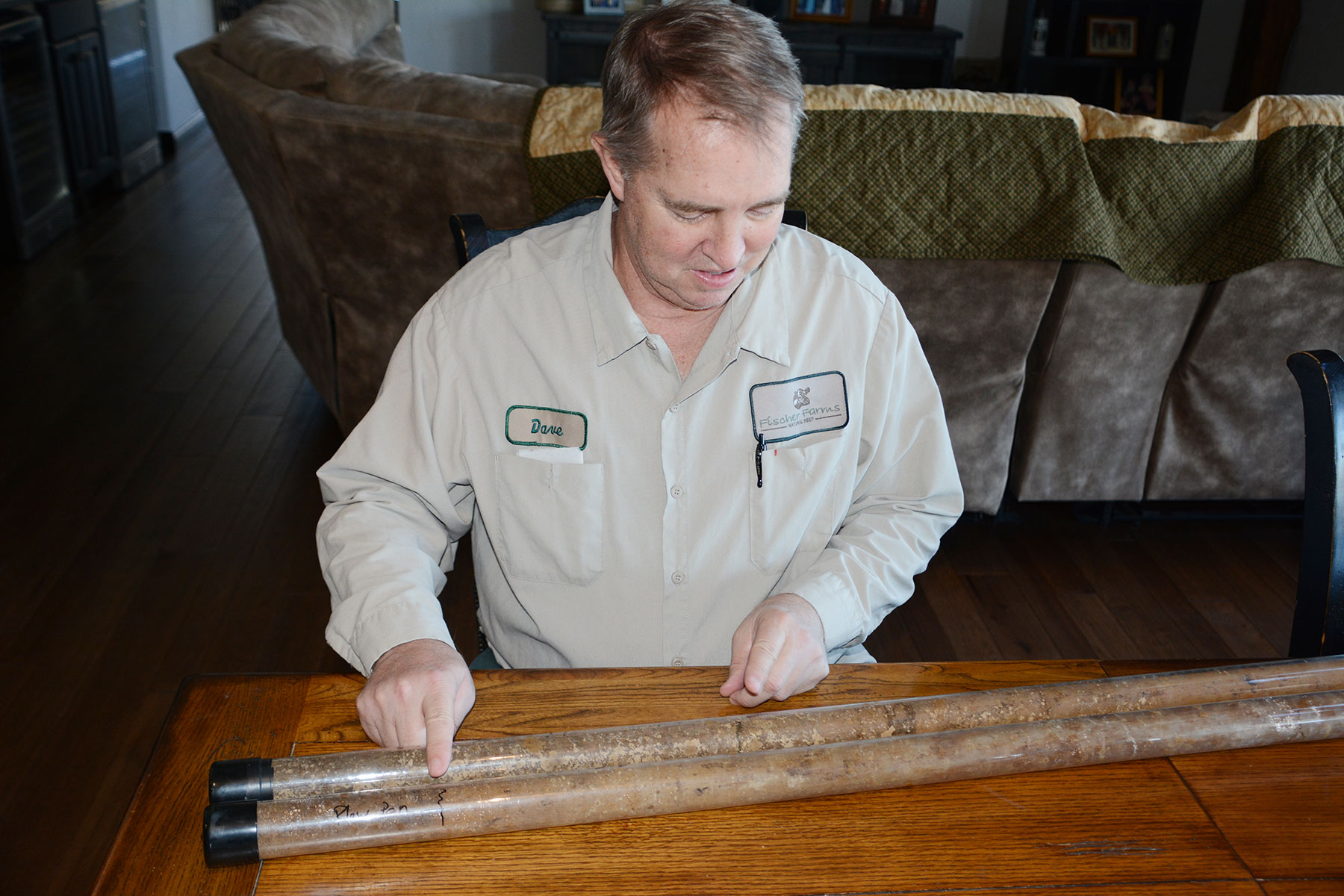 Dave Fischer examining soil profiles in plastic tubes