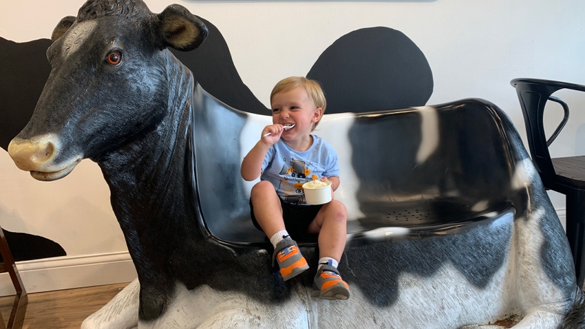 Grayson Jaouni eating ice cream while sitting on cow bench