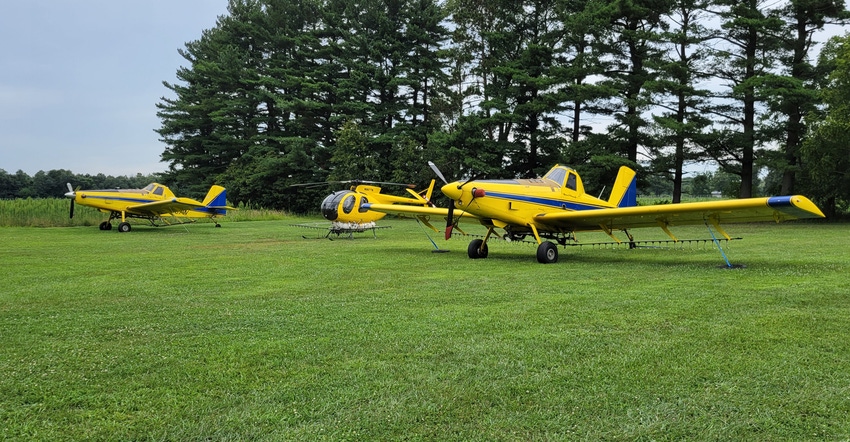 two crop-dusting planes and a helicopter  