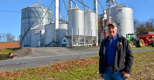 Farmer Mike Braucher, Mohrsville, Pa. with grain bins behind him