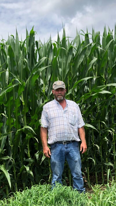 Drew Haines stands beside his record-yielding corn field