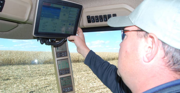 Farmer in cab looking at yield monitor