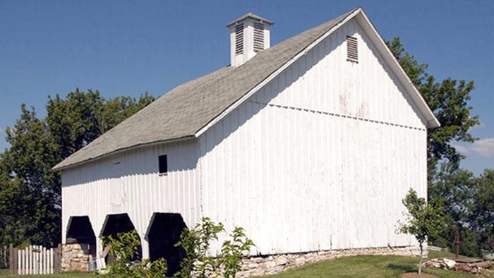 white asymmetrical barn with three bays