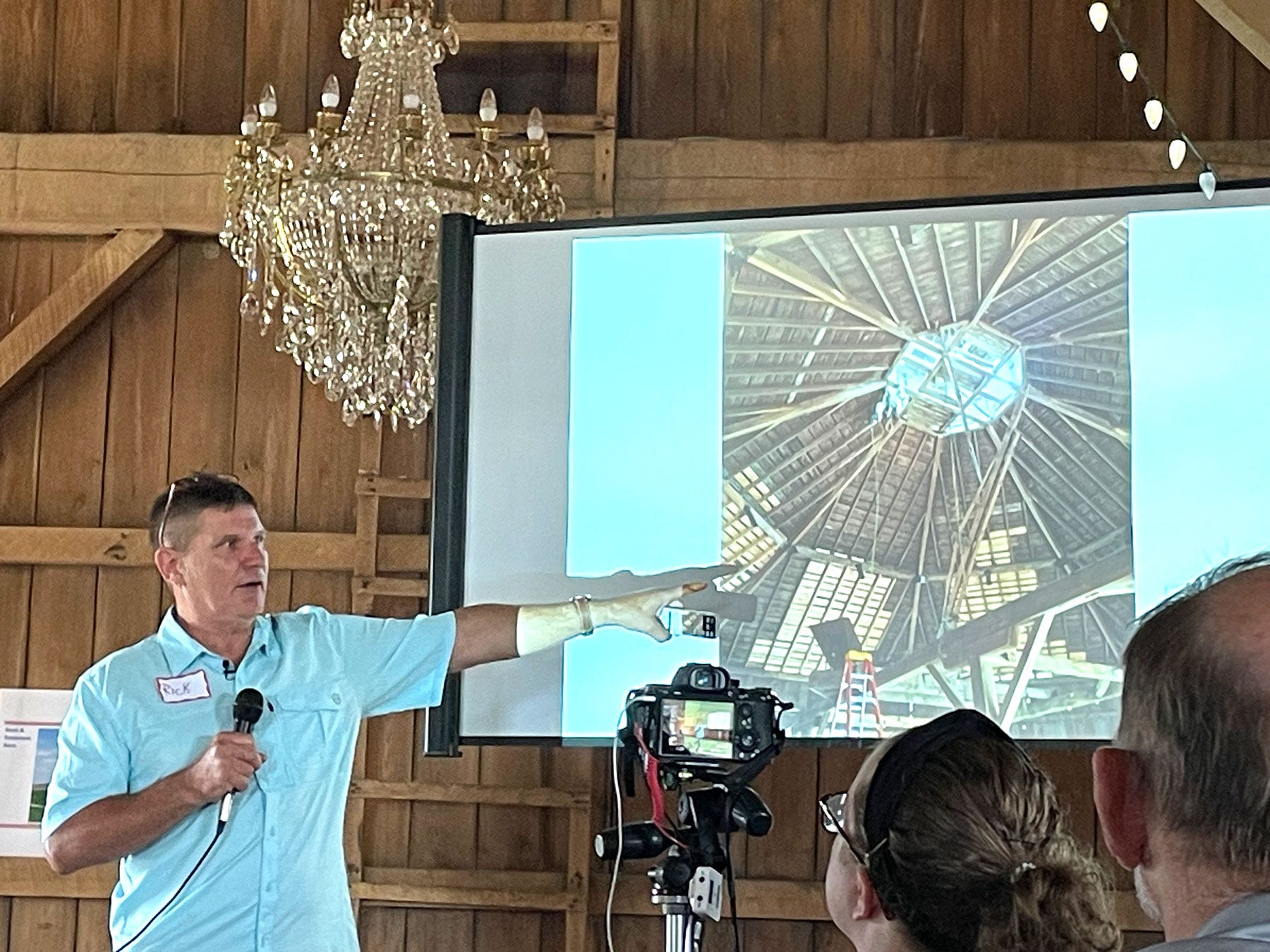 Rick Collins shows pictures of a round barn restoration project to the Indiana Barn Foundation 