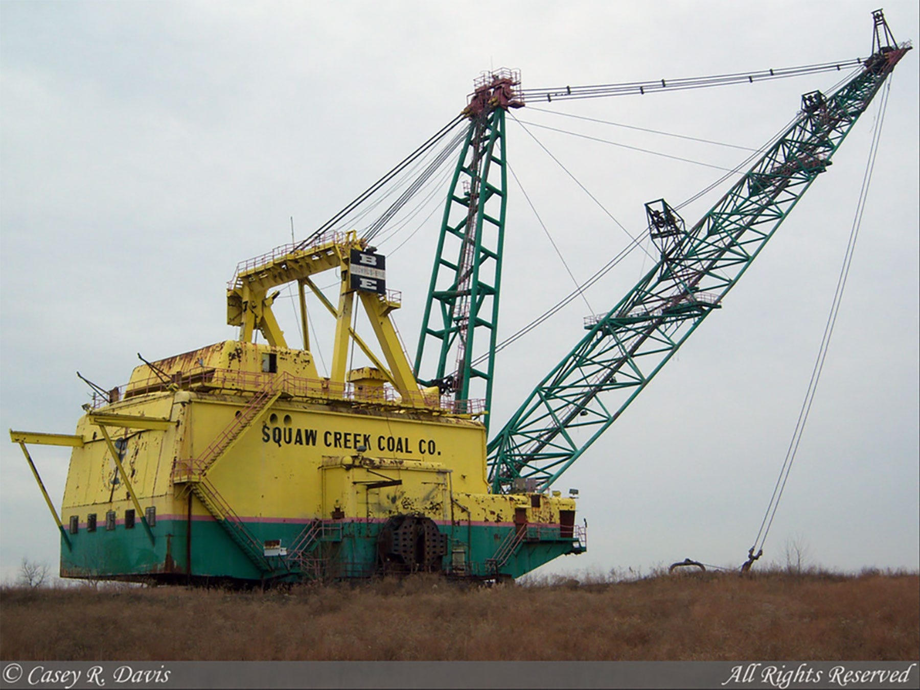 A yellow and green dragline used for excavating in mining