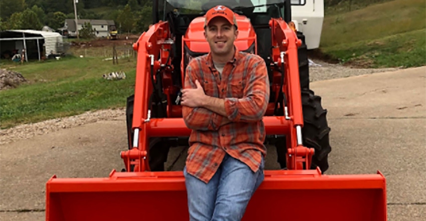 Joshua Nelson sitting on bucket of Kubota tractor .jpg