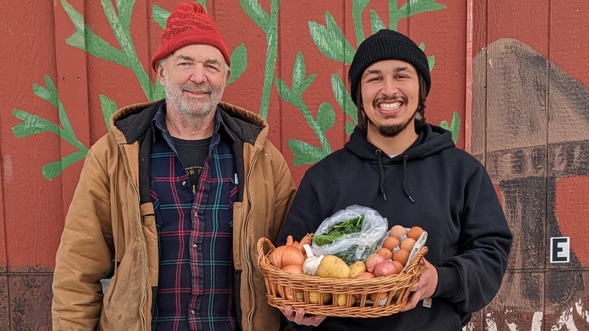 Richard Andres and Alex Ball holding a basket of farm fresh products