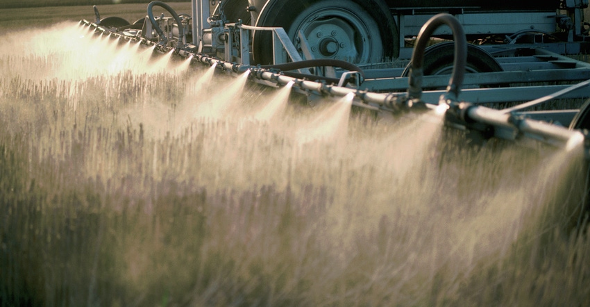 Detail of nozzles spraying herbicide on field